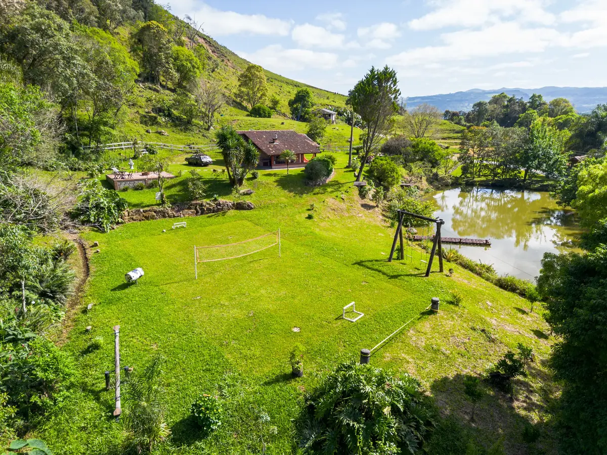 O sítio visto do alto: o vale inteiro, com o lago, os gramados e a mata em volta das duas hospedagens