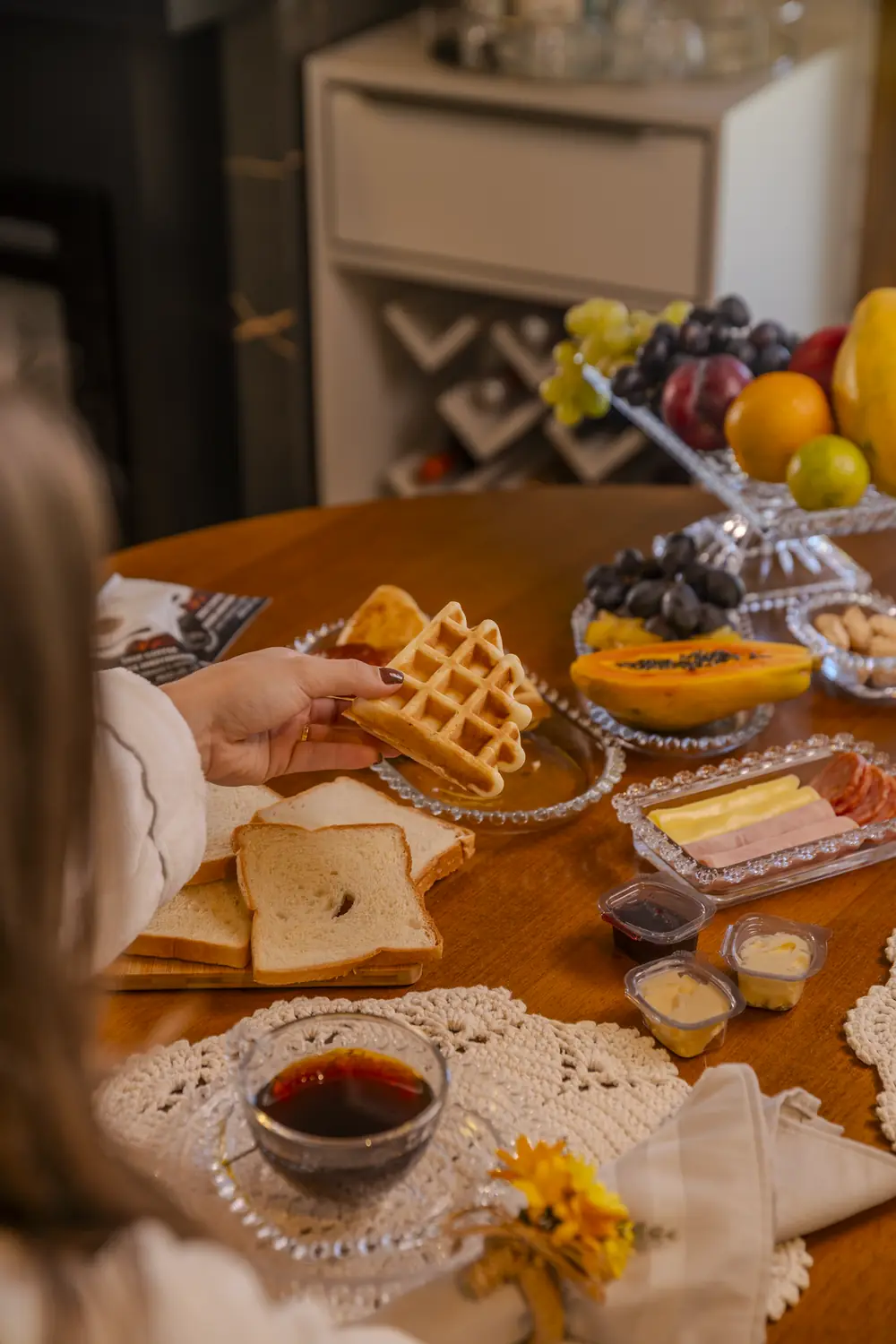 Cesta de café da manhã servida na cabana, com frutas, waffles, pães e café