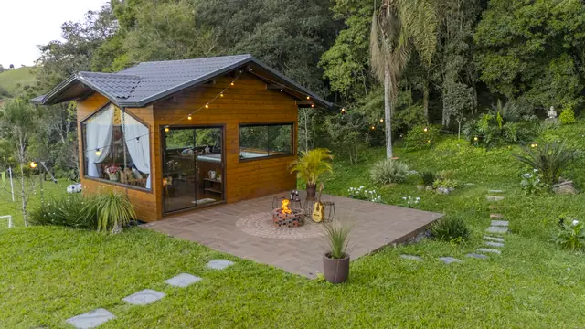Spa de madeira com luzinhas e fogo de chão aceso no gramado
