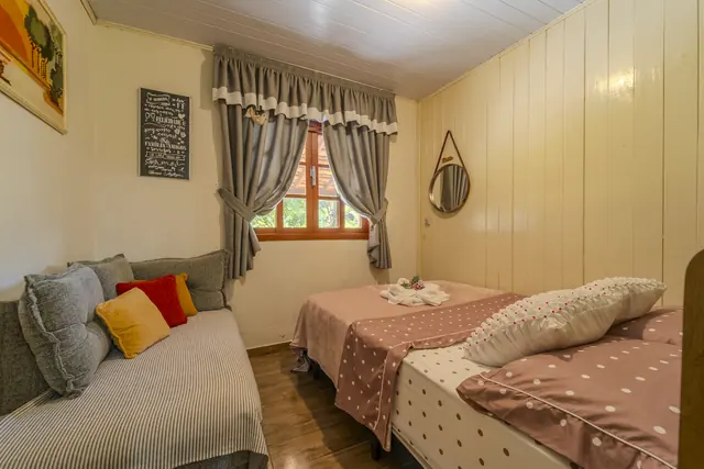 Quarto de casal com sofá e cortinas xadrez