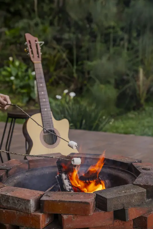 Fogo de chão aceso, com um violão encostado ao lado